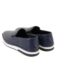 Marine slip-on schoenen van geperforeerd synthetisch materiaal, ronde neus en een witte rubberen zool met een zwart accentstrip. Achteraanzicht weergegeven.