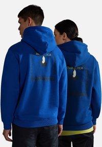 Felpe blu con tasche anteriori, polsini e orlo a coste. Stampa grafica sul retro con un globo e un pinguino; nome del marchio sottostante.