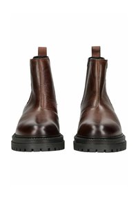 Botas de tobillo de cuero marrón con acabado suave, paneles laterales elásticos, lengüeta de tirón y suela de goma negra gruesa con patrón de tracción.