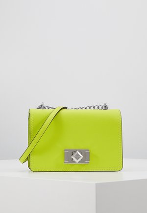 Petit sac à main rectangulaire en cuir jaune-vert vif avec bandoulière en chaîne argentée et fermoir décoratif argenté sur surface blanche.