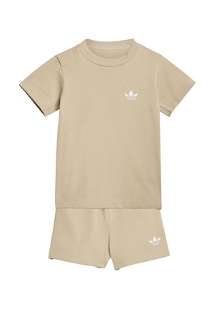 Beiges T-Shirt mit kurzen Ärmeln und passenden Shorts mit kleinen weißen Adidas Trefoil-Logos auf der Brust und am linken Bein.