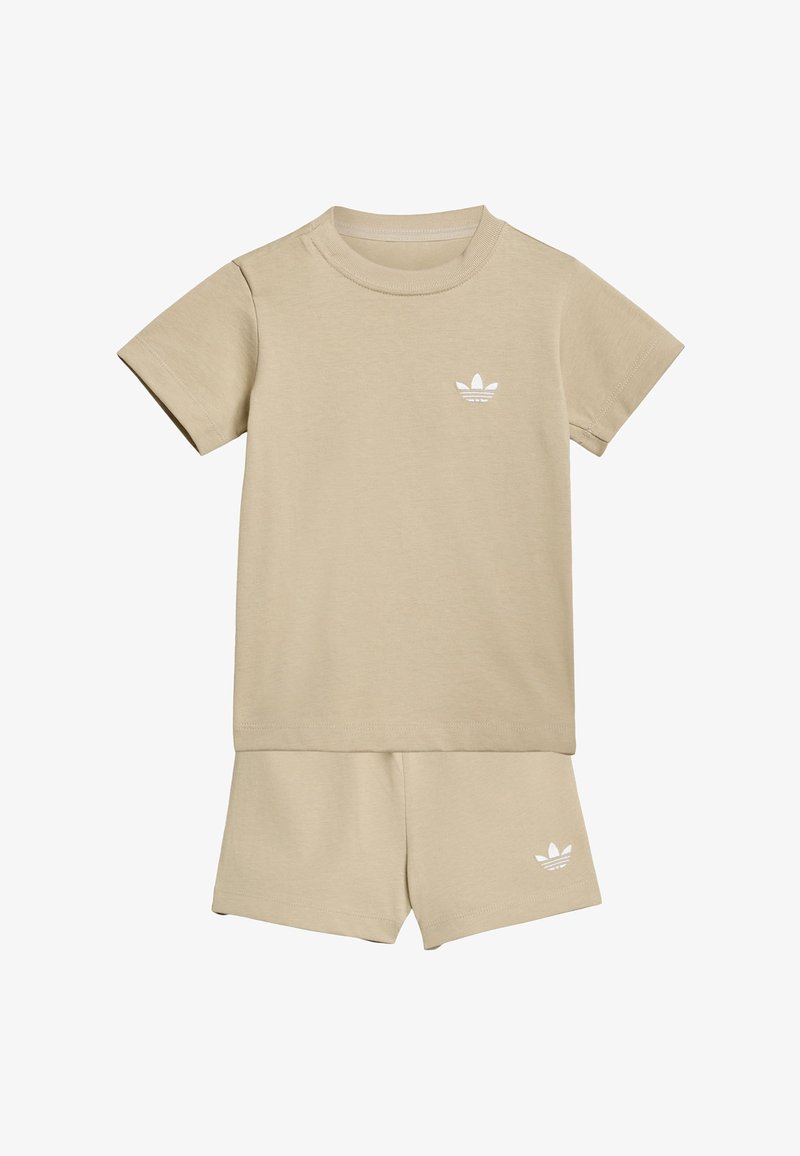 Ensemble beige composé d'un t-shirt à manches courtes et d'un short assorti avec petits logos blancs Adidas trefoil sur la poitrine et la jambe gauche.