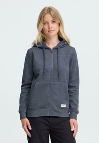 Grå zip-up hoodie i blødt stof med hætte, snore, forlommer og logomærke i kanten. Løs pasform og lange ærmer.