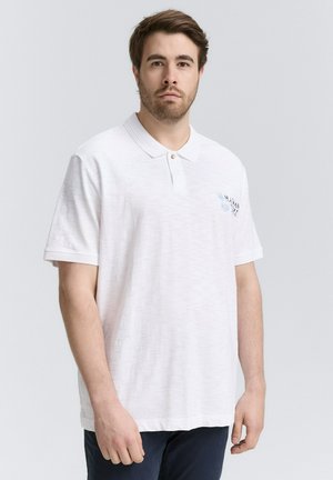 Witte polo met een textuurafwerking, korte mouwen en een twee-knopen knoopsluiting. Heeft een kleine blauwe grafische afbeelding op de borst.