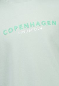 Vaaleanvihreä huppari, jossa on teksti "COPENHAGEN" mintunvärisenä ja "LINDBERGH" valkoisena, pyöreä pääntie, pehmeä tekstuuri, rento muotoilu.