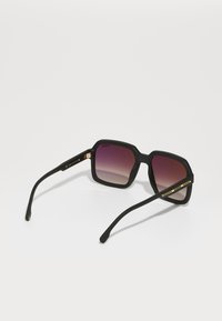 Ochelari de soare negri cu rame pătrate, lentile cu un gradient, finisaj mat și accente aurii pe tâmple. Laturi texturate cu un design aerodinamic.