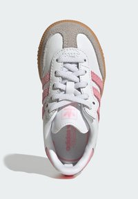 Biało-różowy sneaker wykonany z zamszu i skóry. Posiada trzy różowe paski, okrągły nosek oraz teksturowaną gumową podeszwę.