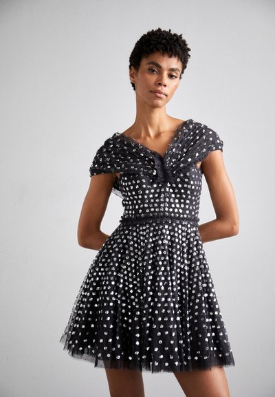 Robe en tulle noire avec des embellissements argentés ; design décolleté, corsage ajusté et jupe évasée. Détails en tissu texturé et superposé.