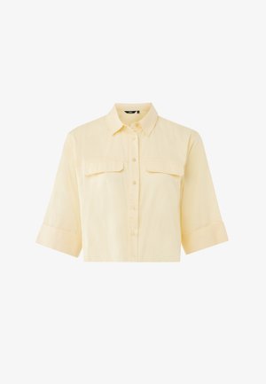 Chemise à manches courtes avec col, en coton jaune clair, dotée de deux poches poitrine, fermeture à boutons sur le devant et manches retroussées. Texture lisse, design minimaliste.