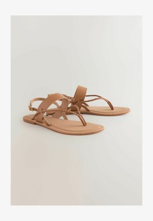 Sandalias planas marrones hechas de material sintético. Presentan correas entrelazadas y un posteo para los dedos. Textura suave con un diseño minimalista.