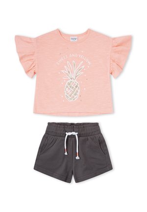 Top rosa con volantes y manga corta con piña dorada y texto “SWEET AND YELLOW”, combinado con pantalones cortos gris oscuro con cordón y bolsillos.