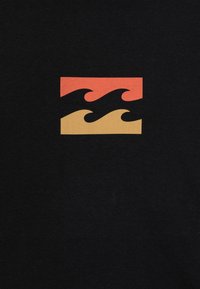 Camiseta negra con un gráfico que presenta un diseño en forma de ola en colores rojo, naranja y amarillo, en formato rectangular. Textura suave y diseño simple y moderno.