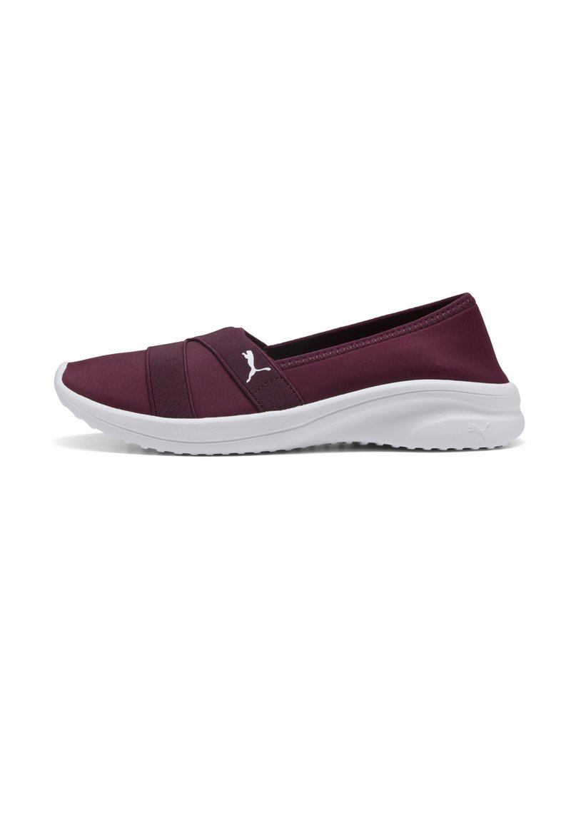 Baskets slip-on marron à semelle blanche rembourrée et brides croisées élastiques avec un logo Puma blanc sur le côté.