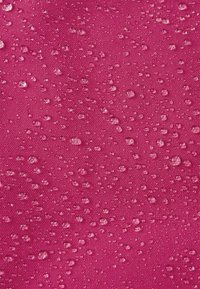 Tessuto rosa resistente all'acqua con una superficie texturizzata, caratterizzato da numerose piccole gocce d'acqua distribuite uniformemente su tutto il materiale.