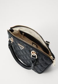 Borsa a tracolla nera imbottita in pelle con dettagli in oro, chiusura zip superiore e scomparti interni. Presenta un manico corto e il logo del marchio.