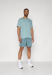 Under Armour LEFT CHEST LOGO - Nyomott mintás póló - serpentine/jasper blue