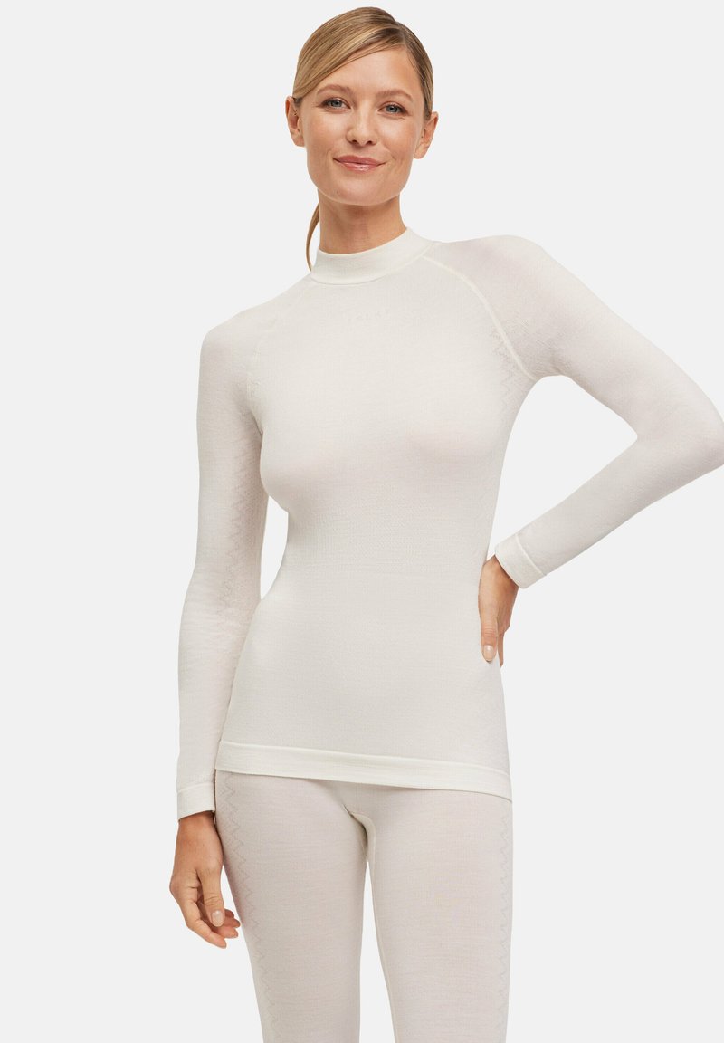 Maglietta termica a maniche lunghe in crema chiaro, con colletto alto, design aderente, texture senza cuciture e un delicato motivo sulle maniche.