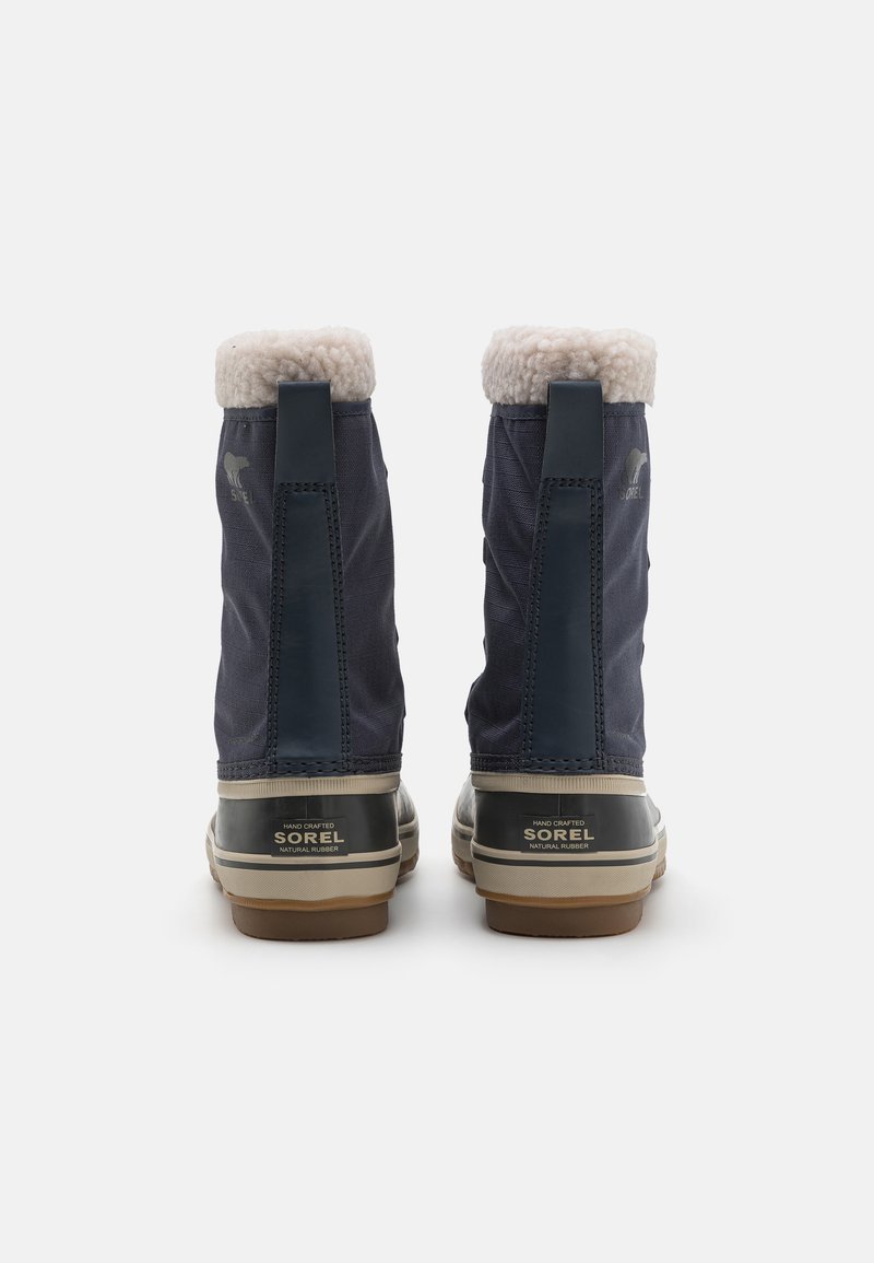 Nawodoodporne buty w kolorze granatowym z podszyciem z sztucznego futra, gumową podeszwą i kontrastującymi jasnobrązowymi akcentami. Zawierają logo oraz pętelkę z tyłu.
