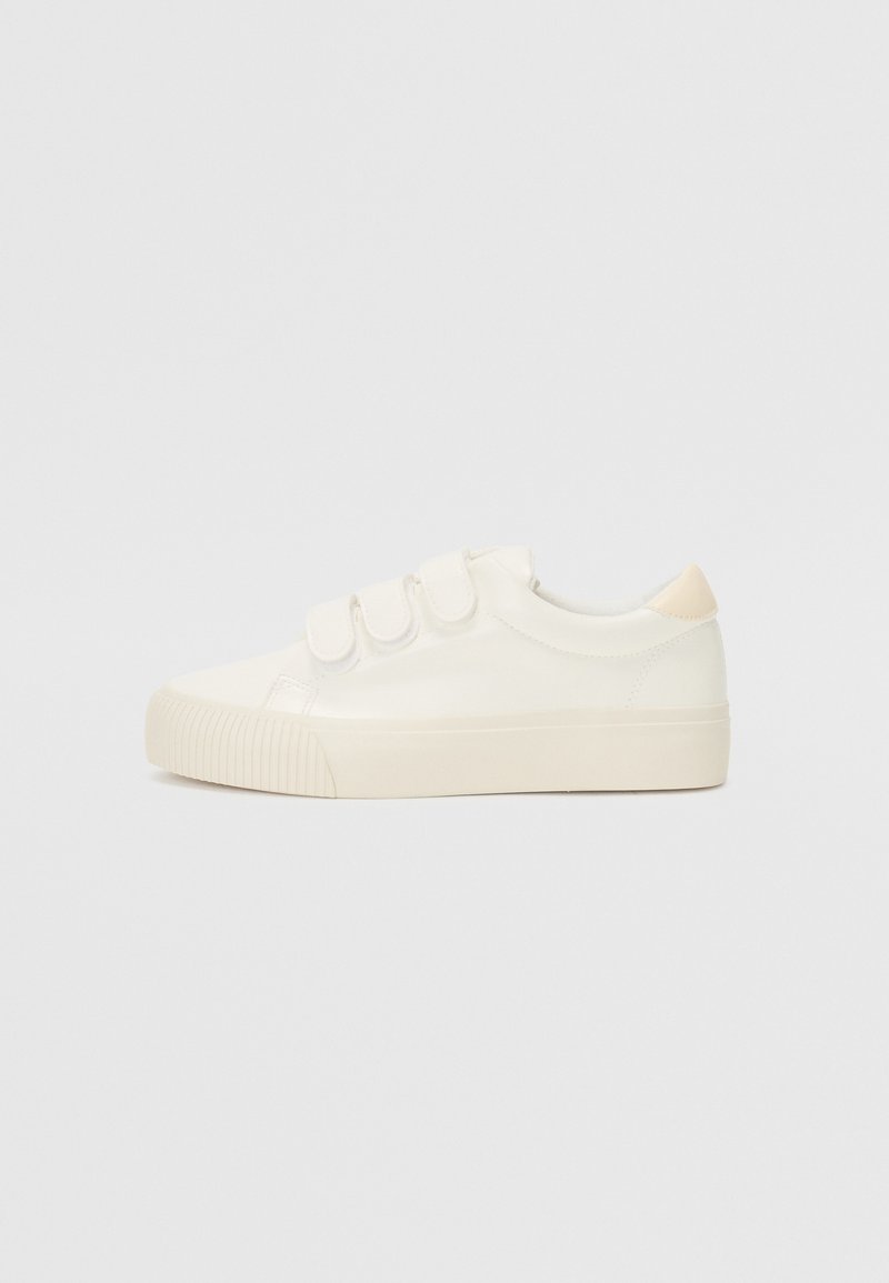 Witte sneakers met een gladde leren uitstraling, drie klittenbandsluitingen, ronde neus en een gestructureerde rubberen zool. Achteraccent in beige.