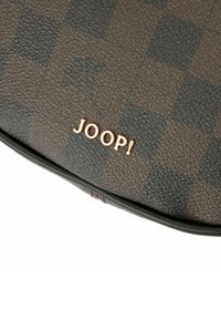 Borsa in pelle marrone con motivo a scacchiera testurizzato, con un logo dorato "JOOP!" nella parte inferiore e una forma elegante e arrotondata.