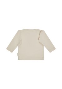 Light beige long-sleeve top with puffed sleeves, crew neck, and a small tag on the left side near the hem. Smooth cotton material.