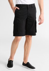 Shorts cargo noirs en coton, dotés de poches latérales et d'une coupe décontractée. La taille comprend des passants de ceinture et une fermeture à bouton.