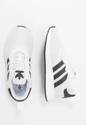 Baskets Adidas blanches en mesh avec des bandes noires, vues de dessus et de côté sur un fond blanc.
