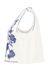 Witte mouwloze top met blauwe bloemborduursels en gegolfde randen. Zachte textuur, relaxte pasvorm en ronde halslijn.