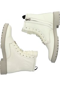 Bottes à cheville en cuir blanc avec une finition texturée, dotées d'une semelle grise robuste, d'un laçage à l'avant et d'une fermeture éclair latérale pour un accès facile.