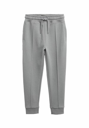 Pantalon de survêtement gris clair avec taille élastique, cordon de serrage, poches latérales, détails de coutures sur les jambes, et poignets côtelés aux chevilles.