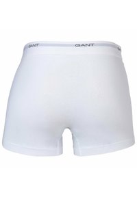 Boxer shorts in cotone bianco con una texture liscia, caratterizzati da una cintura grigia con logo e un design a vita media.