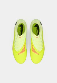 Par de botas de fútbol de color amarillo neón con marcas negras y rojas, vistas desde arriba sobre un fondo blanco.
