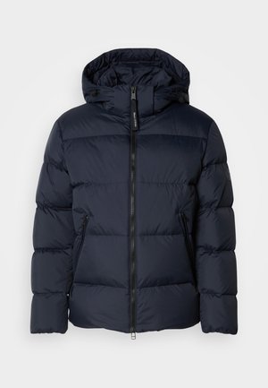 Marineblauwe gewatteerde jas met capuchon, met horizontale gestikte secties en een ritssluiting aan de voorkant. Inclusief zijzakken en stoffen accenten.