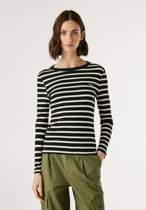 Camicia a maniche lunghe a righe bianche e nere in tessuto a coste, con scollatura rotonda e un discreto dettaglio del logo sul lato sinistro del petto.