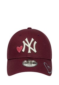 Bordeauxfarbene Baseballmütze mit weißem, gesticktem "NY"-Logo, rotem Herzelement und blauem Herzakzent an der Seite. Verstellbares Größenetikett sichtbar.