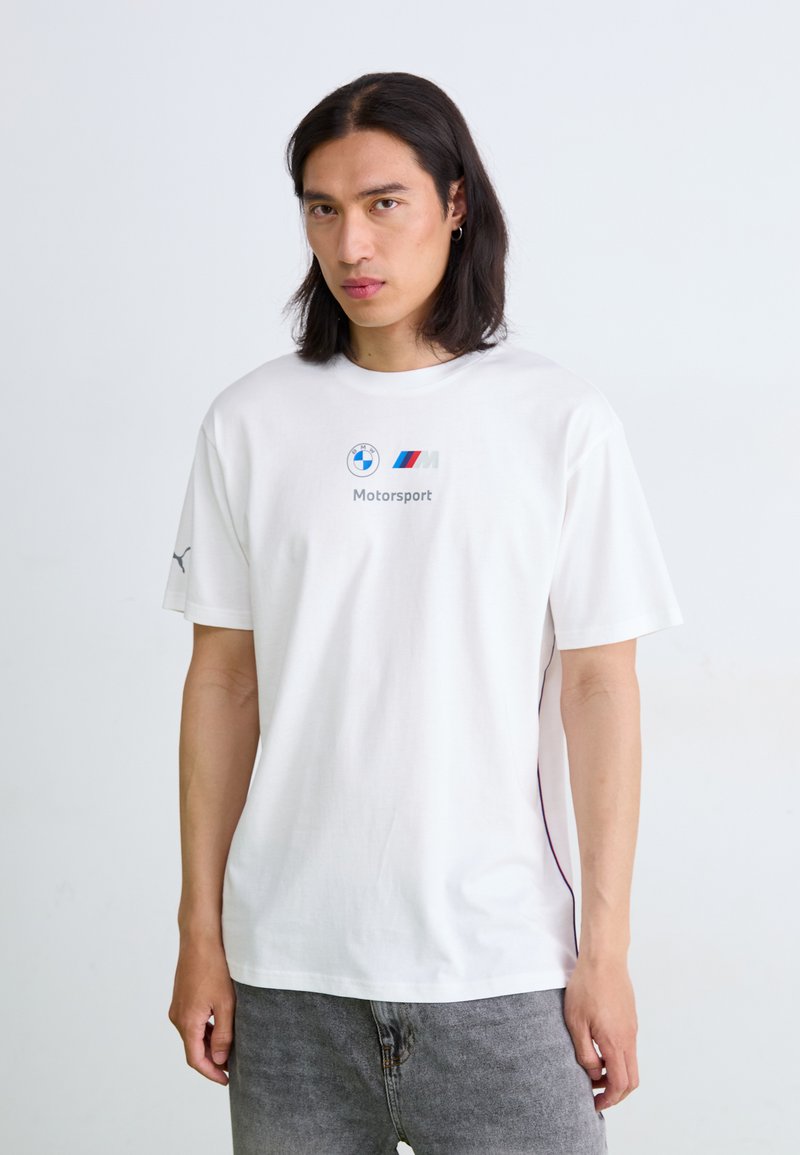 Hvid bomulds-t-shirt med korte ærmer, som har et BMW-logo, M Motorsport-tekst og en subtil sideaccent i mørk farve.