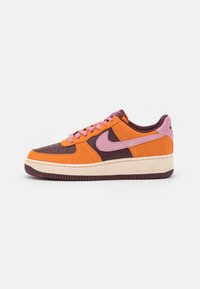 Nike Air Force 1-sneakers har en ovandel i mocka i orange, vinrött och rosa med en lager-på-lager-design, rund tå och kontrasterande snören.
