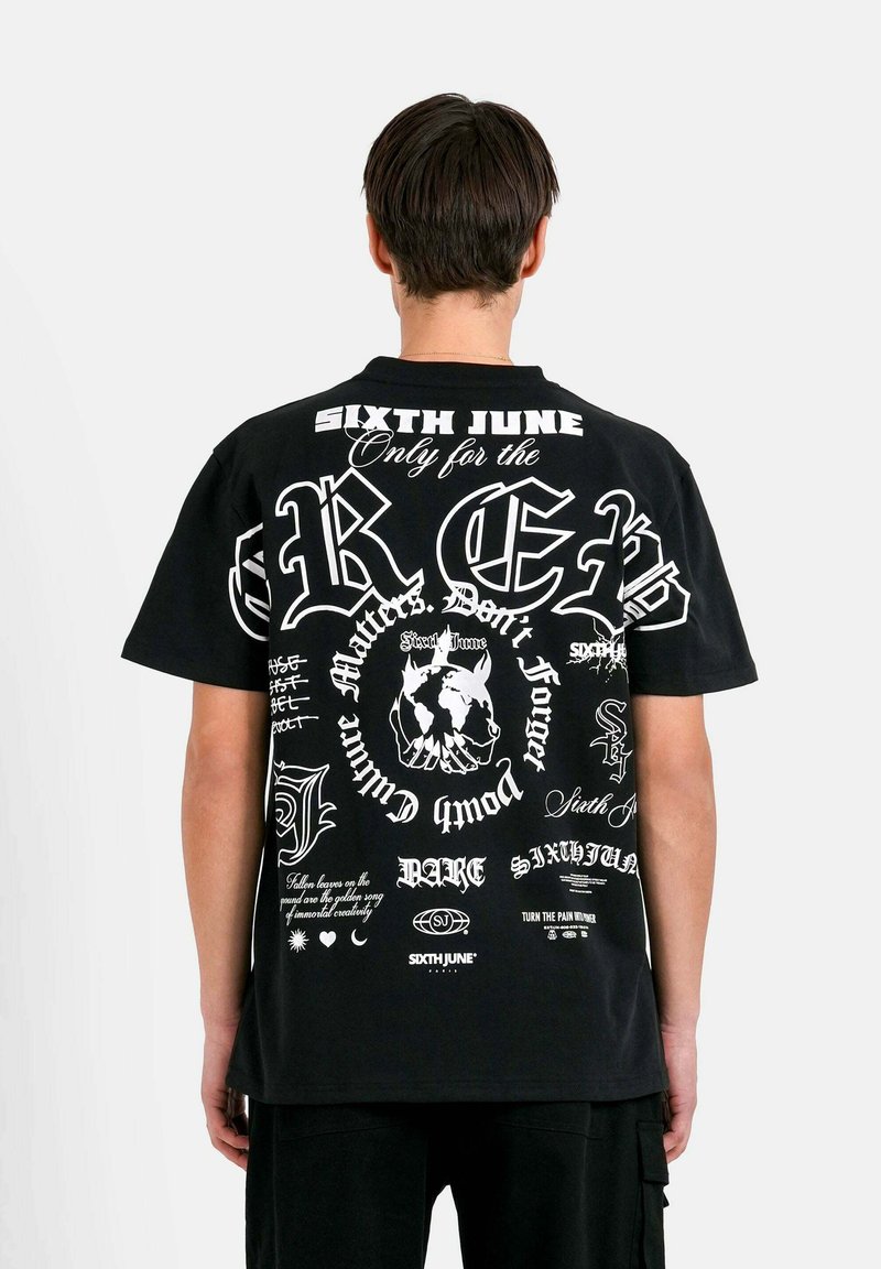 Zwarte grafische t-shirt met diverse witte tekstontwerpen, waaronder logo's en zinnen, met een ontspannen pasvorm en korte mouwen.