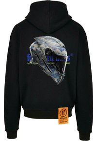 Fekete kapucnis felső, hátán kék és fehér mintázatú sisak grafikával, szöveggel és egy narancssárga címkével az oldalán.