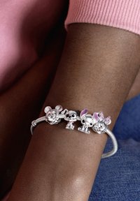 Braccialetto di charm in argento con charm a forma di personaggi: Topolino, un cane, Stitch e Minnie Mouse, caratterizzato da design dettagliati e accenti colorati.