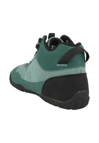 Green and black outdoor shoes with a textured upper, padded collar, and rubber sole featuring hexagonal patterns for grip.