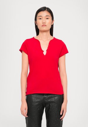 Top rosso a maniche corte con scollatura a V, caratterizzato da una fila di bottoni decorativi lungo il colletto. Realizzato in tessuto morbido e leggero.