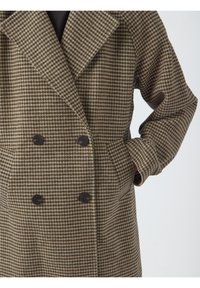 Abrigo de doble botonadura en patrón de jaquard marrón y beige, con grandes solapas, dos bolsillos frontales y botones oscuros. Textura de tela suave.