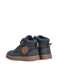 Botines azul marino con acabado en cuero texturizado, que cuentan con una correa de velcro, parche redondo con logo y suela de goma con agarre texturizado.