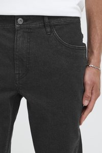 Černé džíny z denimu s rovný střih, pět kapes, zapínání na knoflíky a zip, jemně vybledlá látka.