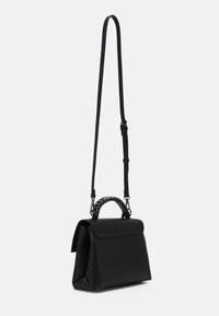 Svart strukturerad handväska med en slät yta, en kedjehandtag på toppen och en justerbar axelrem.