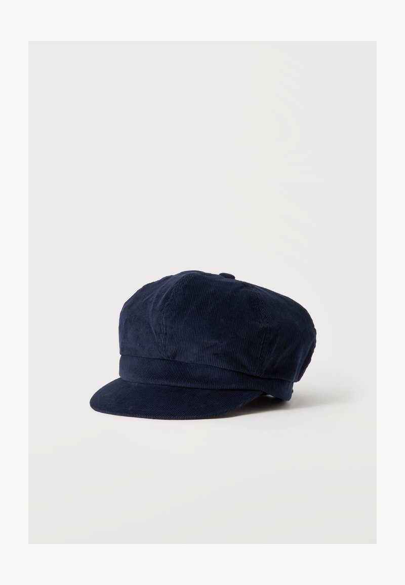 Casquette plate en velours côtelé bleu marine avec une large visière rigide et une bande ajustée autour de la base, présentée sur un fond blanc.