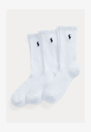 White crew socks with ribbed texture, featuring a small navy logo of a horse and rider. Sold in a pack of three pairs.