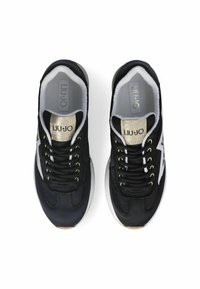 Zapatillas deportivas negras con una parte superior de textil suave, acentos blancos y detalles de logotipo metálicos. Con cordones redondos y una lengüeta acolchada.