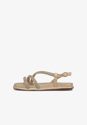 Beige flache Sandale mit drei dünnen, strukturierten Riemen über dem Fuß und einem verstellbaren Knöchelriemen mit goldener Schnalle, seitlich gezeigt.